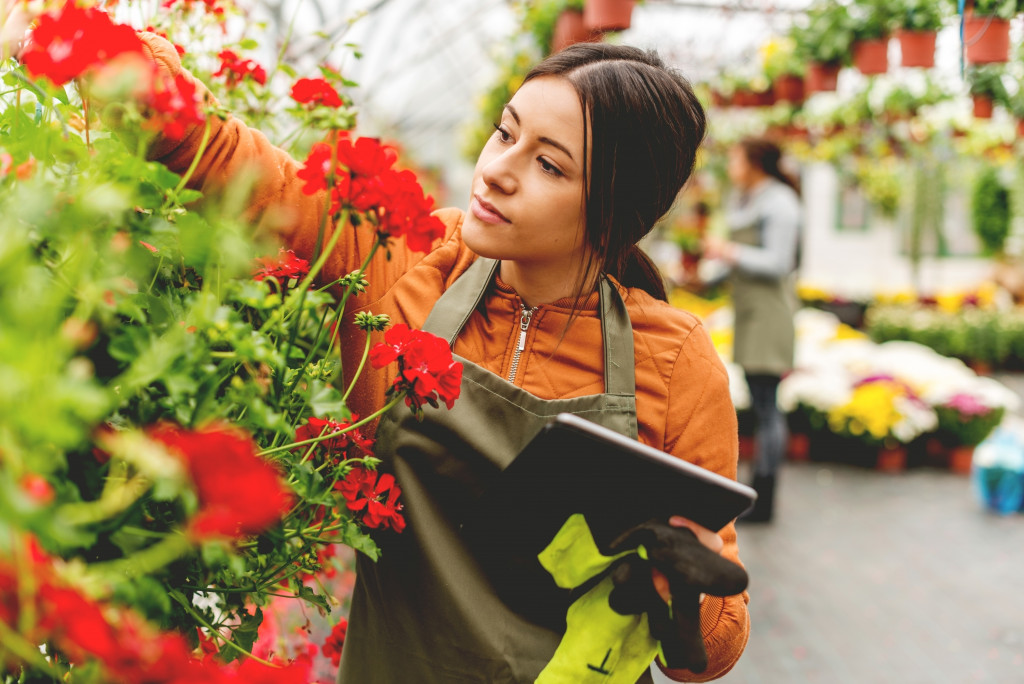 Owner of a flower store checking flowers in the store. 