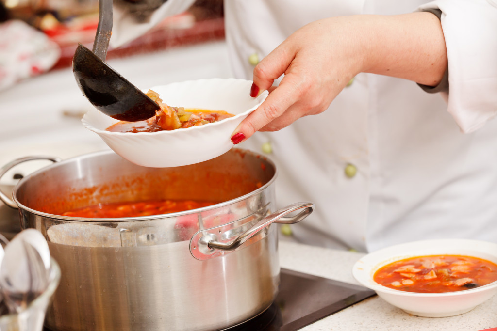 a chef placing a soup in a bowl