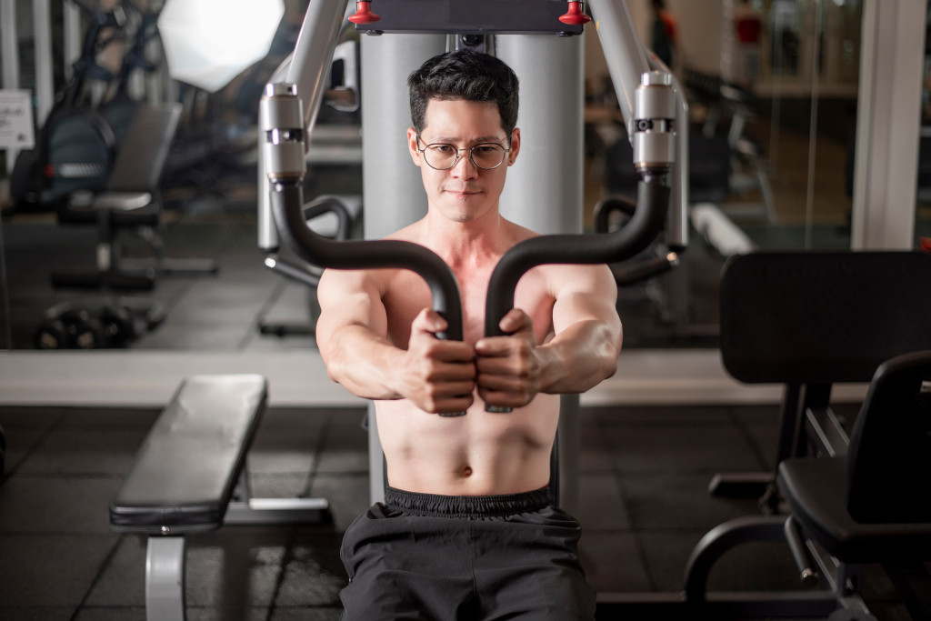 A handsome shirtless man exercising in the gym