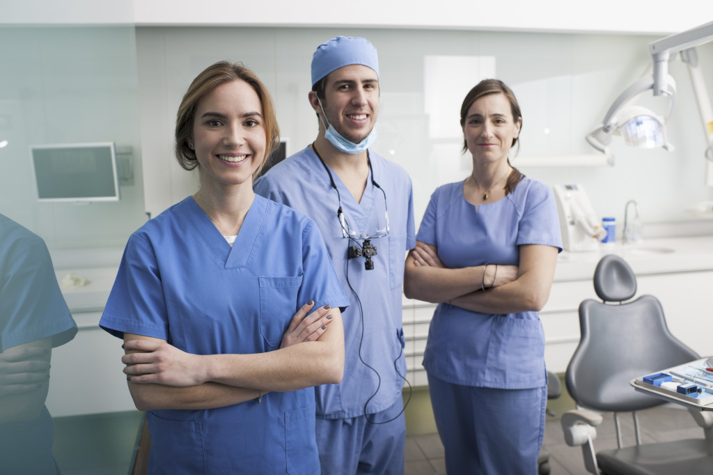 Cheerful group of dentists and their assistants standing in the dental office