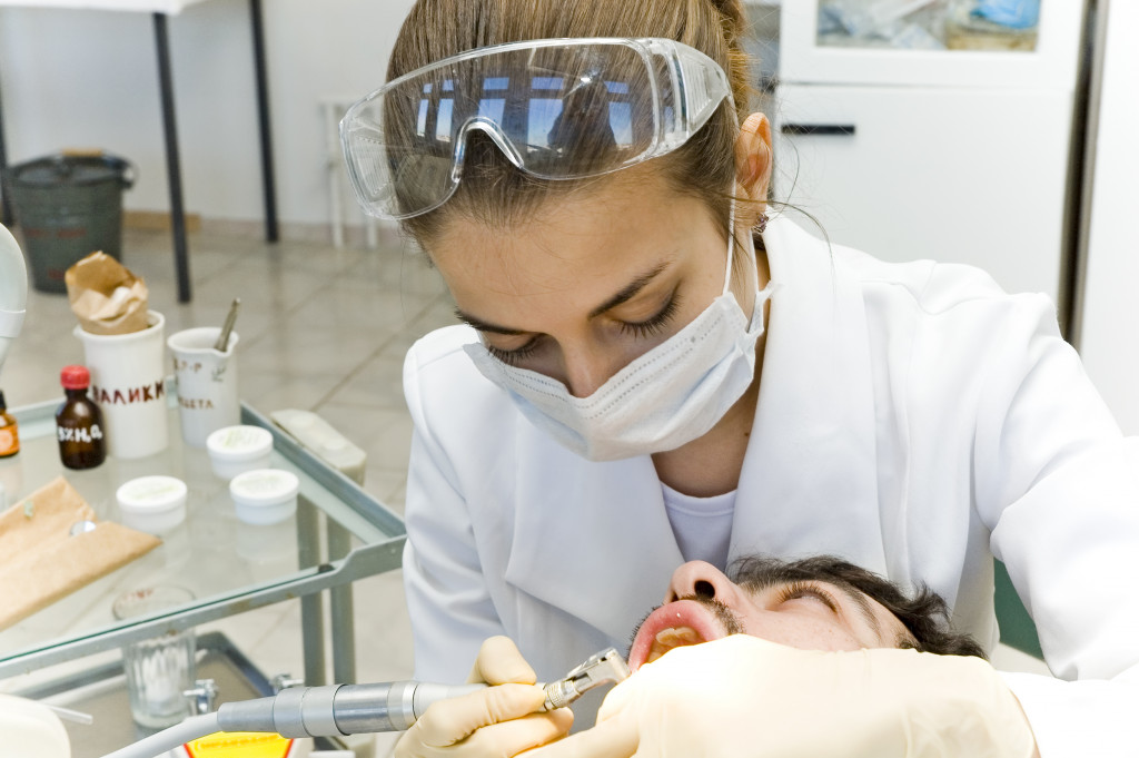 Dentist cleaning teeth of the patient