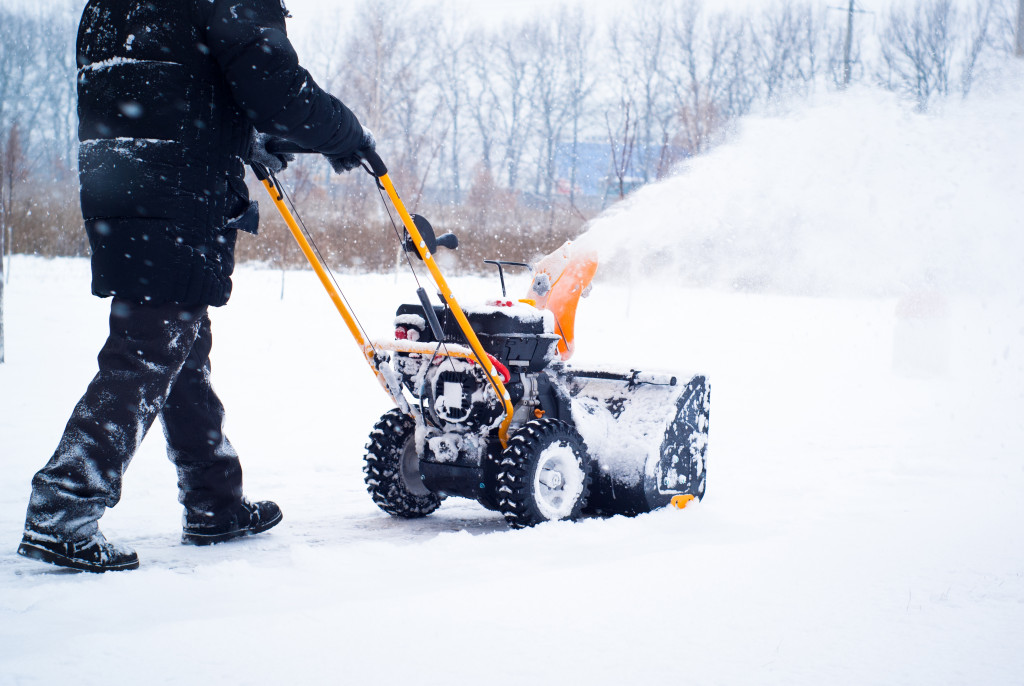 A man removing snow away from his property