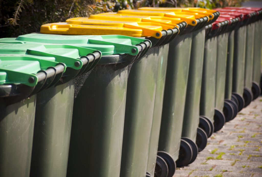 Different colored bins arranged in a row outdoors