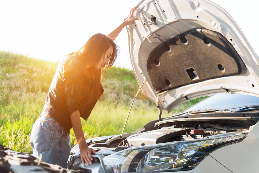 A girl checking the car hood