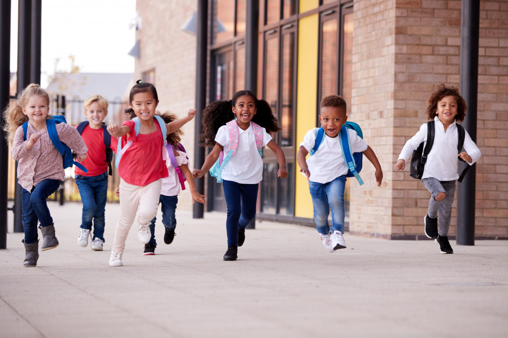 kids happily running to school with backpacks