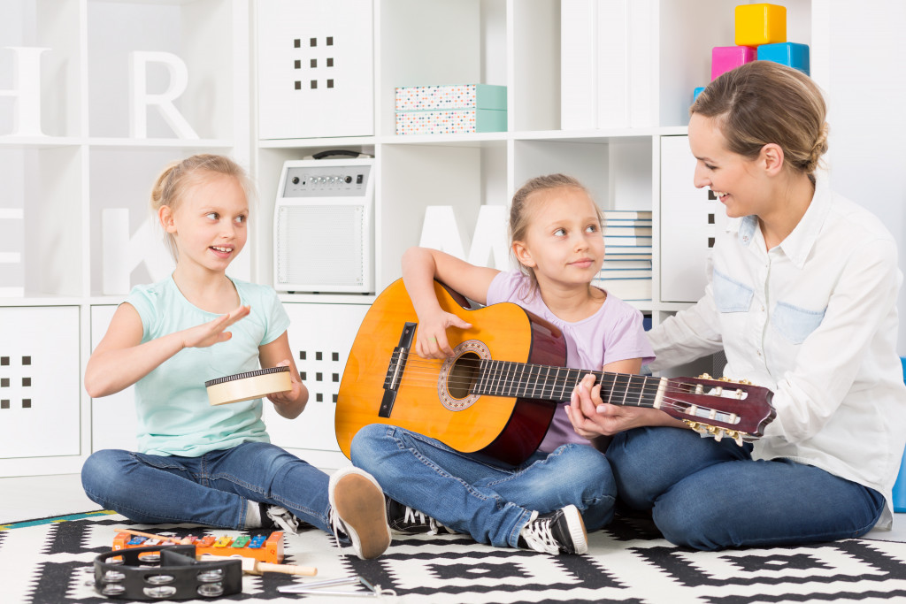 Two children learning the guitar