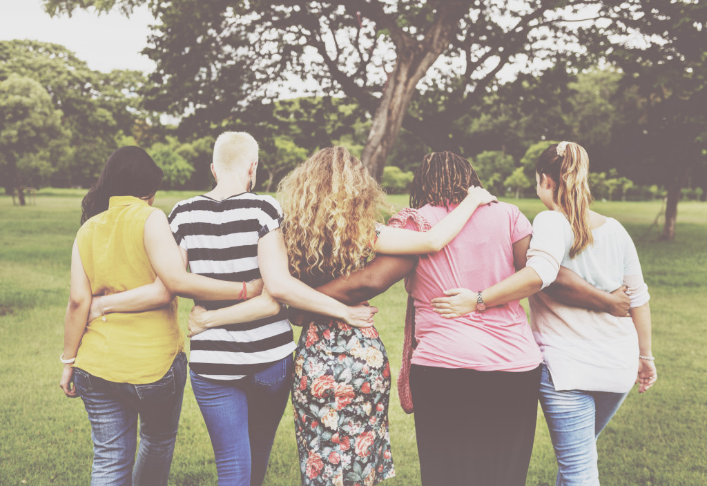 A group of women holding each other in a park