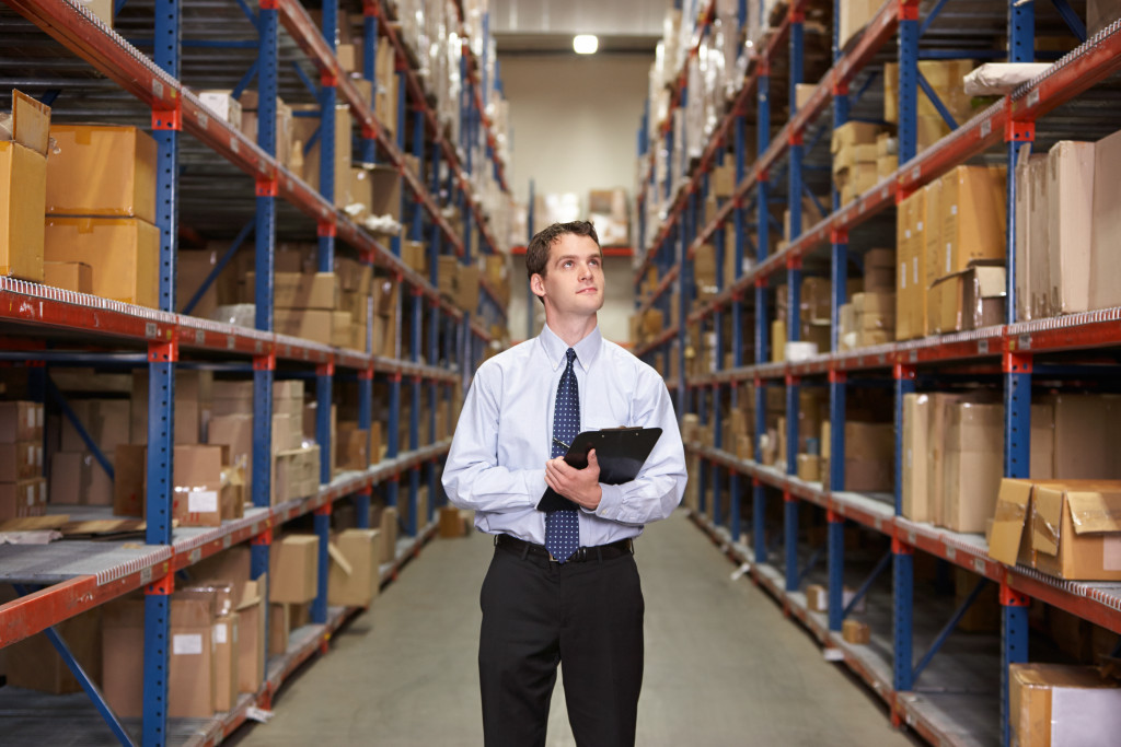 man walking in an empty aisle with boxes