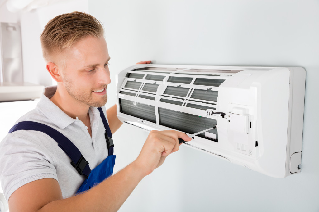 man working on a plist yype aircon