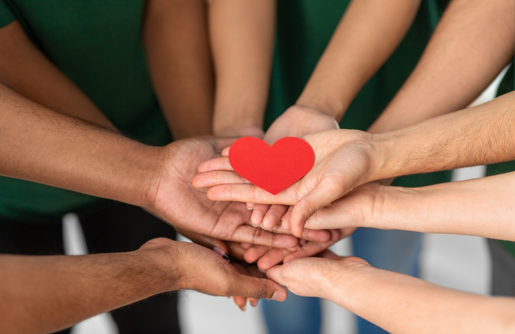 nonprofit planning with different hands holding red heart