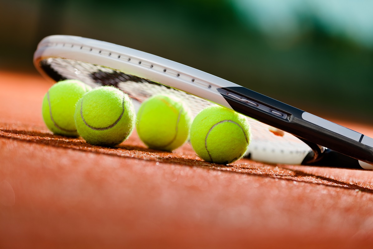 Tennis balls and a racket on a court