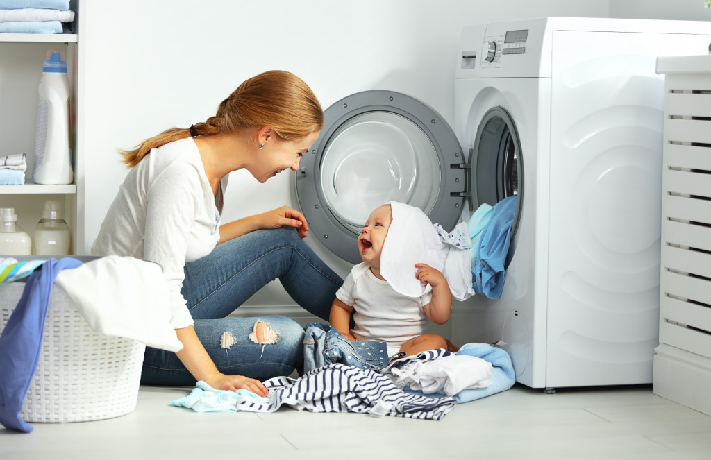 Mother doing laundry with her baby.