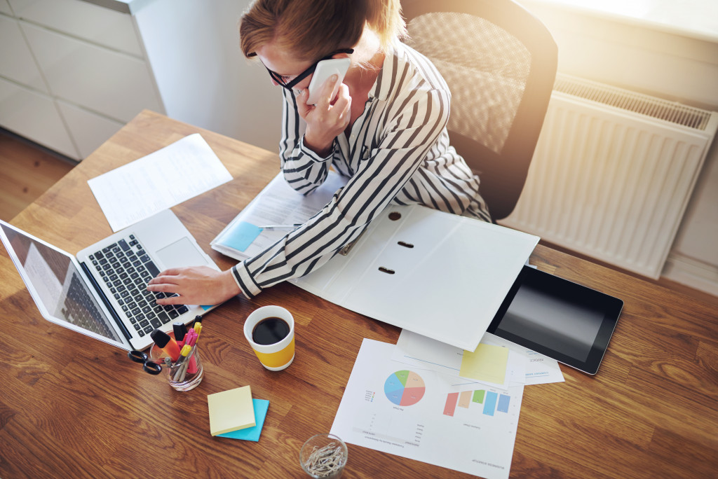 business owner calling while using her laptop