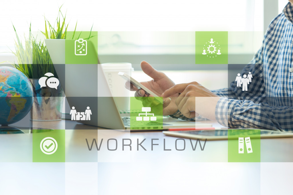 graphic overlay of green icons representing streamlined business operations with man using laptop and phone for work