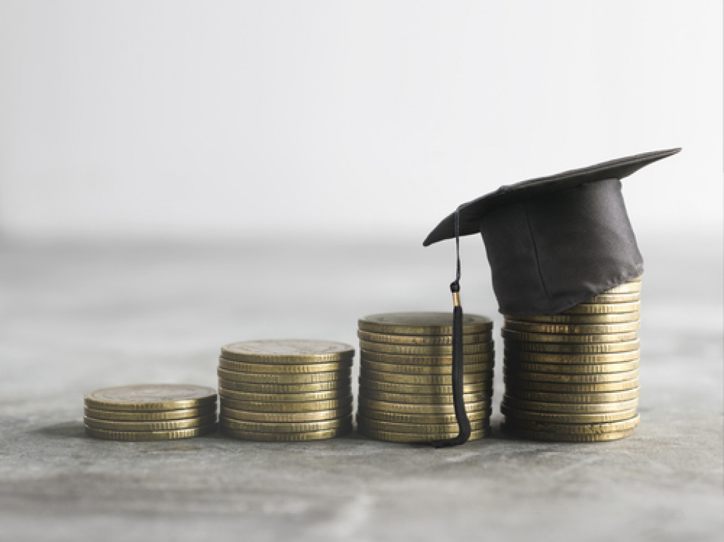 Stacks of coins and a miniature graduation cap