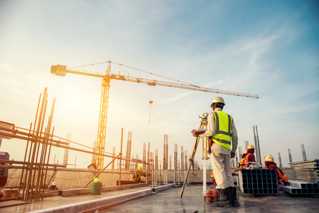 workers overlooking a huge crane in the sunset working in the site