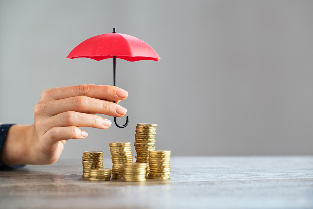 A mini red umbrella over stacks of coins