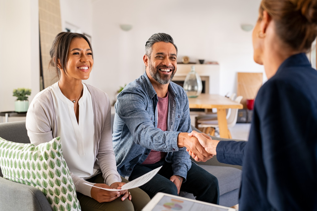 young couple meeting an agent for a property holdign contractc