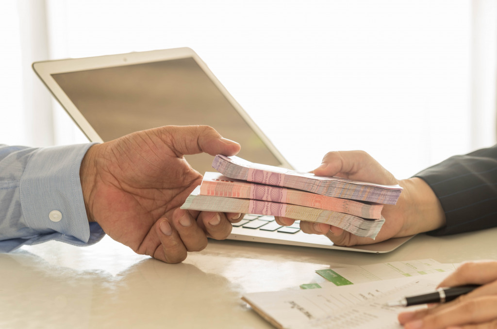 Businessman handing money to a bank employee for savings. 