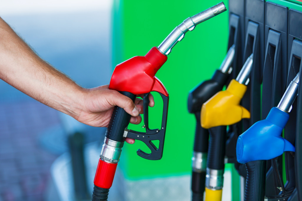 A gasoline station staff holding a fuel pump