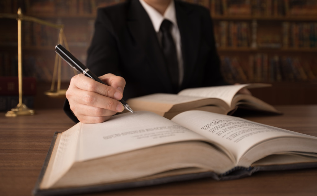 closeup of a lawyer's hands signing or writing in a book in his office