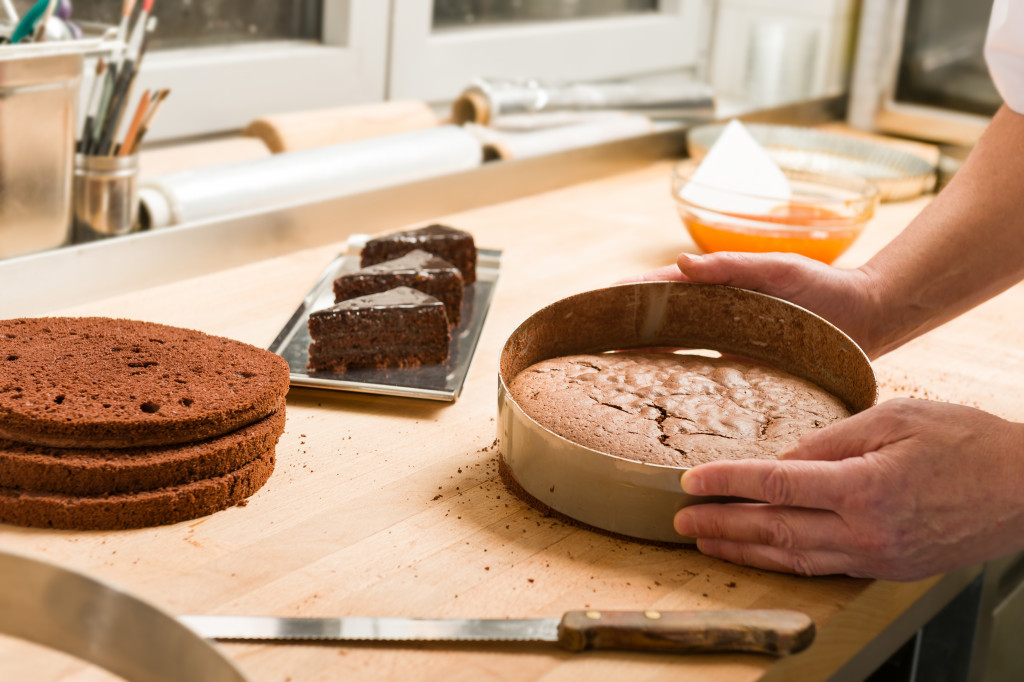 A baker removing a cake from its mold