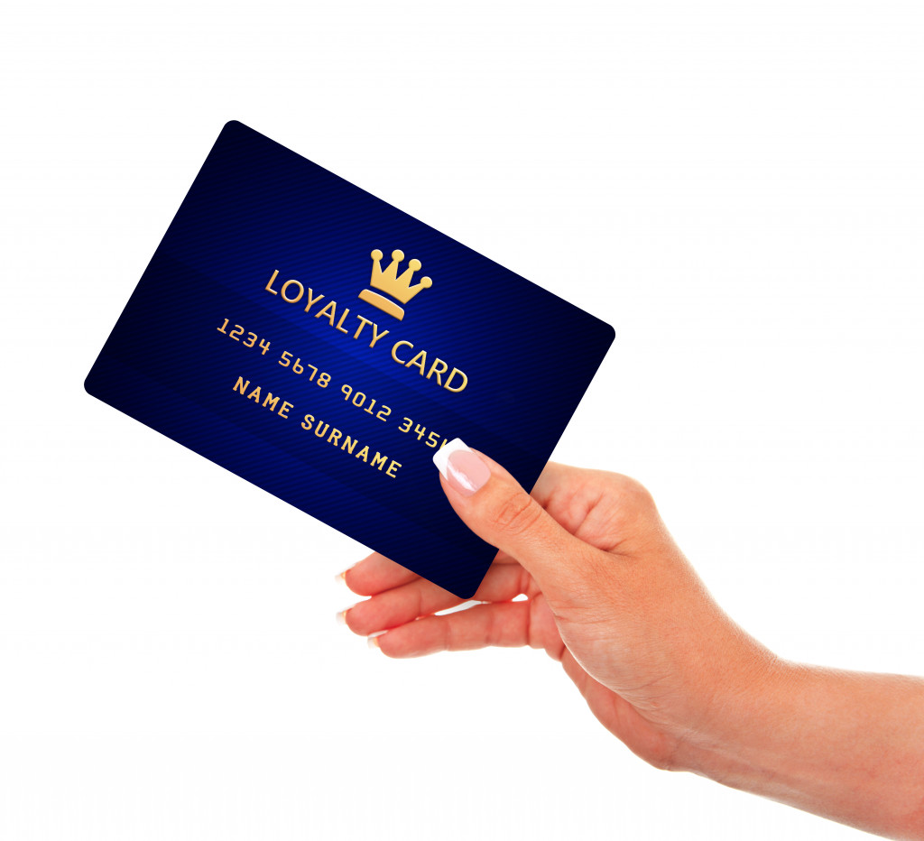 Woman holding a blue loyalty card.
