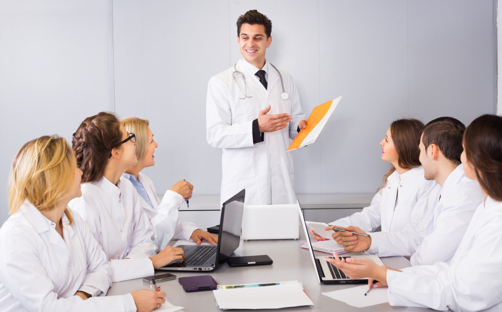 a group of medical professionals listening to a doctor's lecture