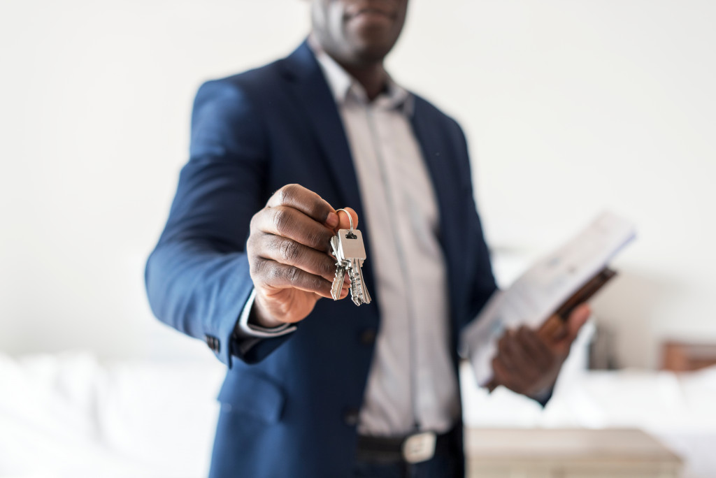 a real estate agent pointing the keys at the camera