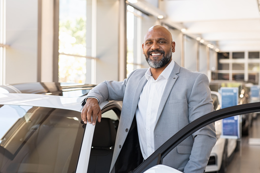 salesman standing in car showroom