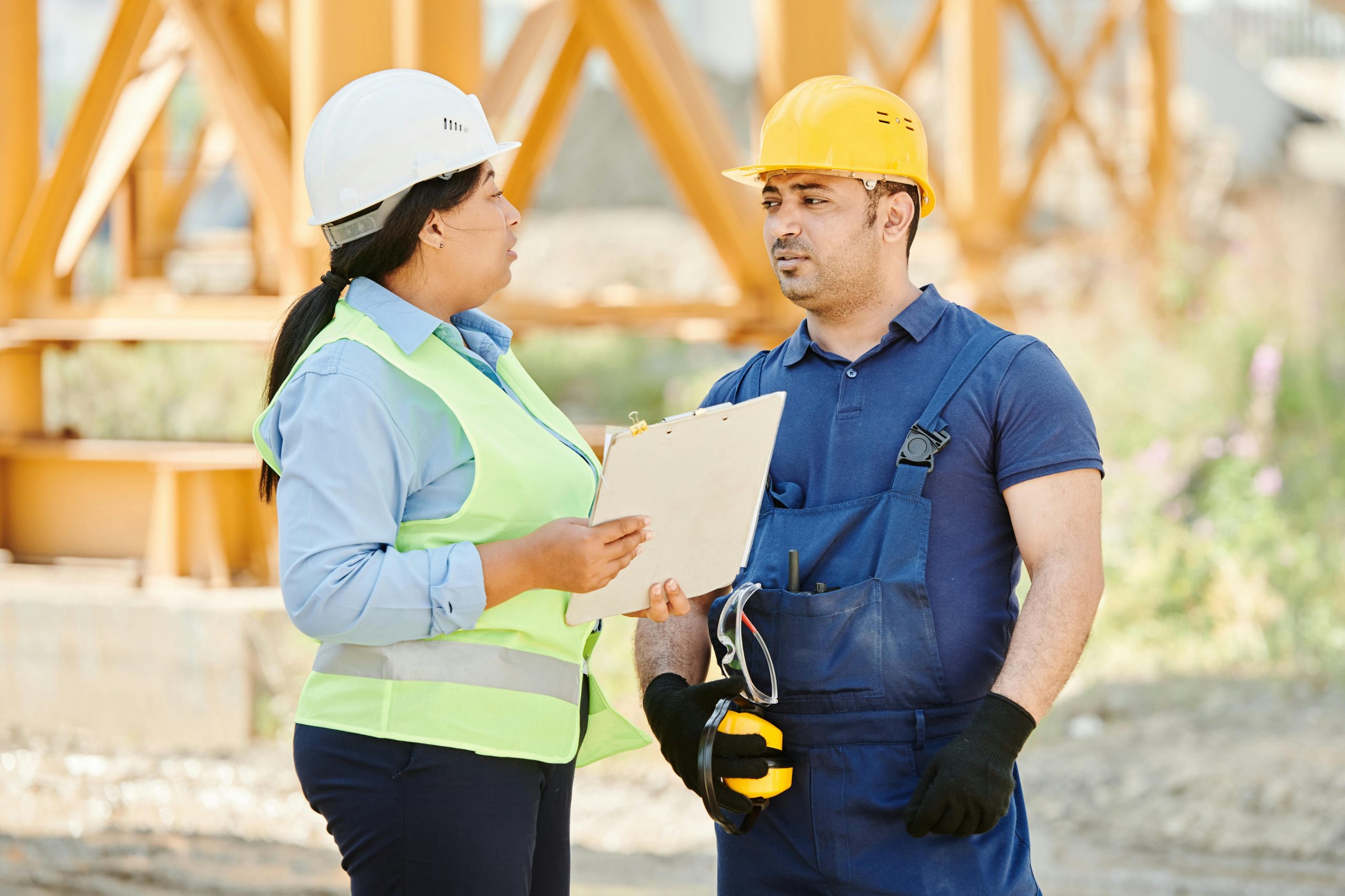 professionals in safety gear talking at a construction site